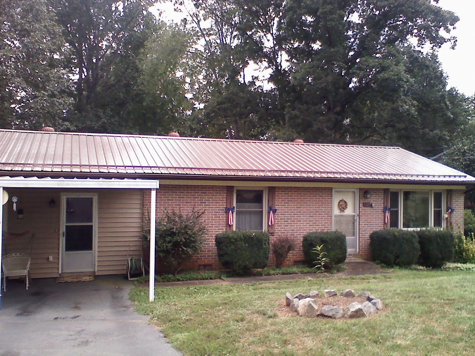 Bronze metal roof and carport on a brick ranch home — Roof Repair work by our crew in Crestline